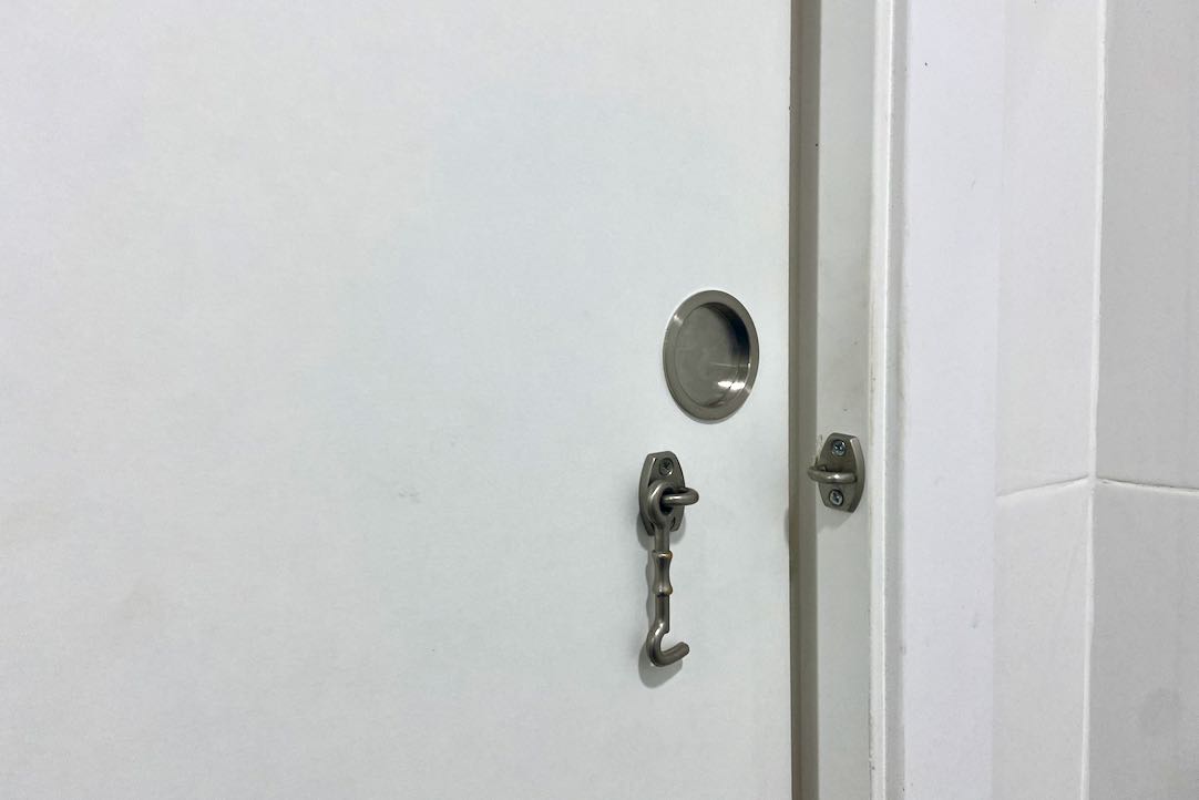 Mecanismo de apertura interior y cerrojo de la puerta del aseo para PMR