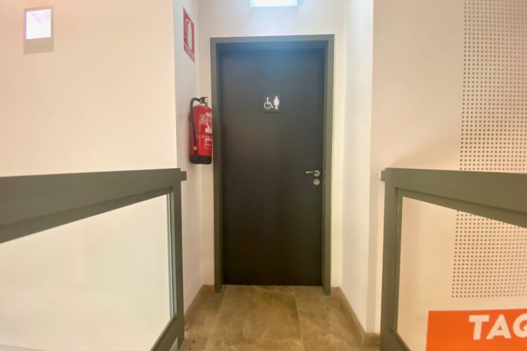 Puerta de acceso exterior del aseo PMR / Mujeres
