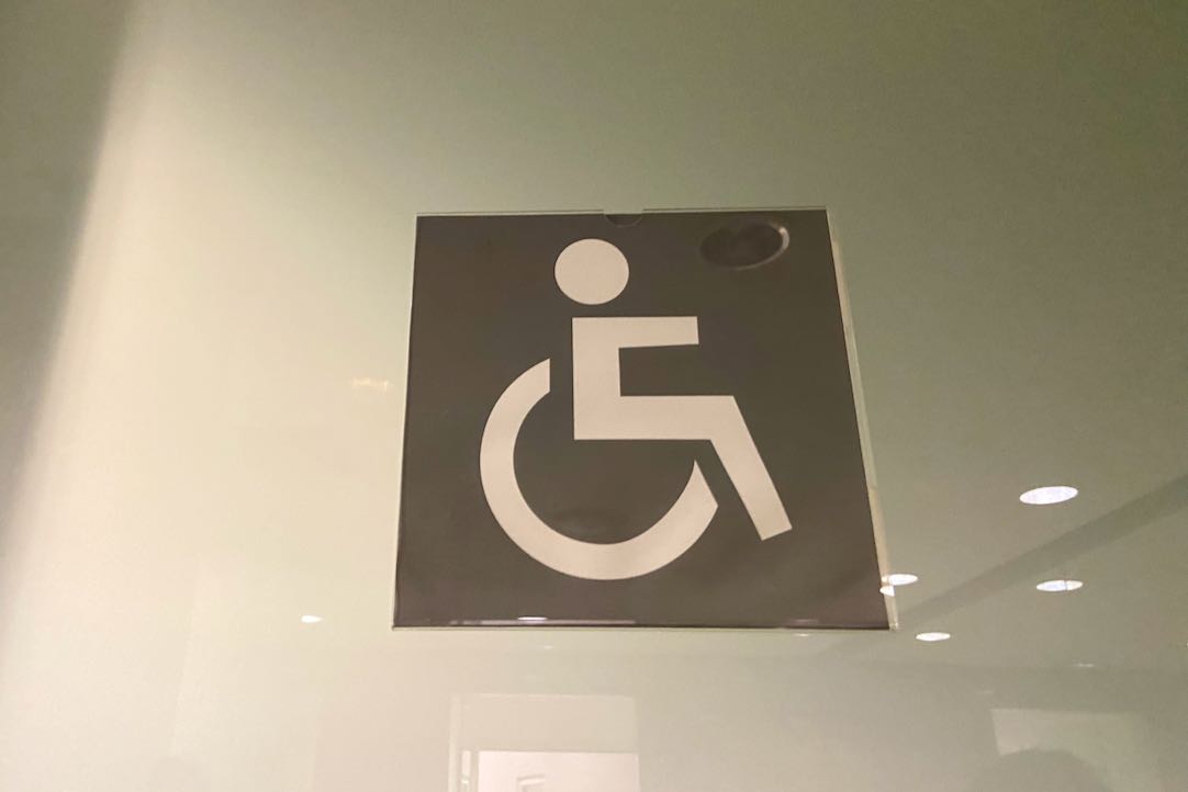 Señalización de la puerta del aseo PMR de hombres