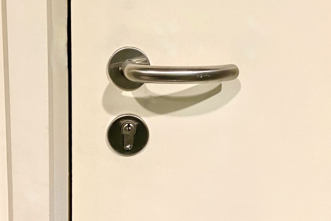 Mecanismo interior de la puerta del aseo común de mujeres