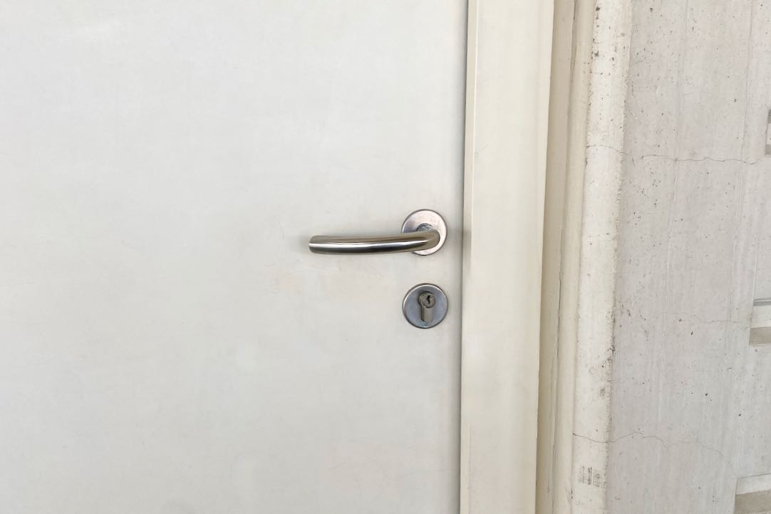 Mecanismo exterior de la puerta del aseo común de mujeres