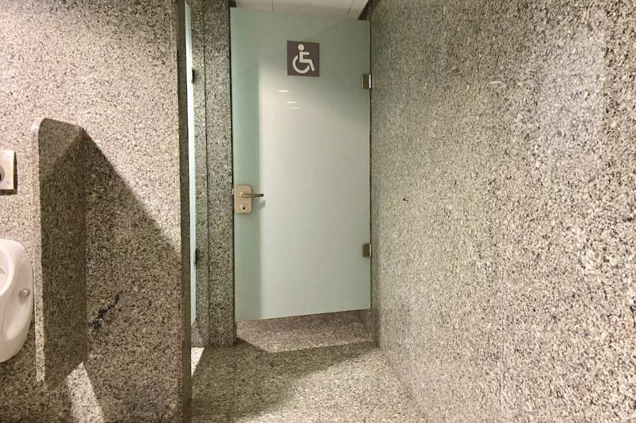 Pasillo interior de acceso al aseo PMR de hombres