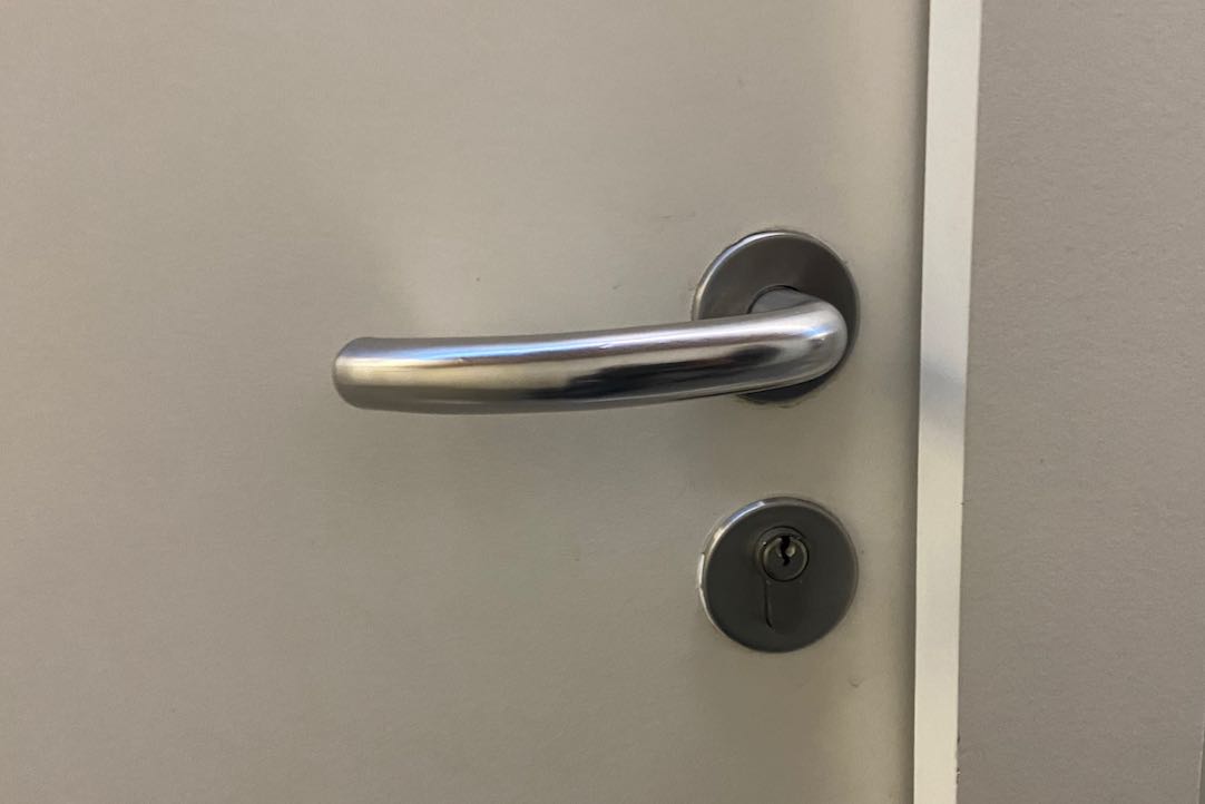 Mecanismo apertura puerta exterior aseos comunes de hombres (Platea Alta)