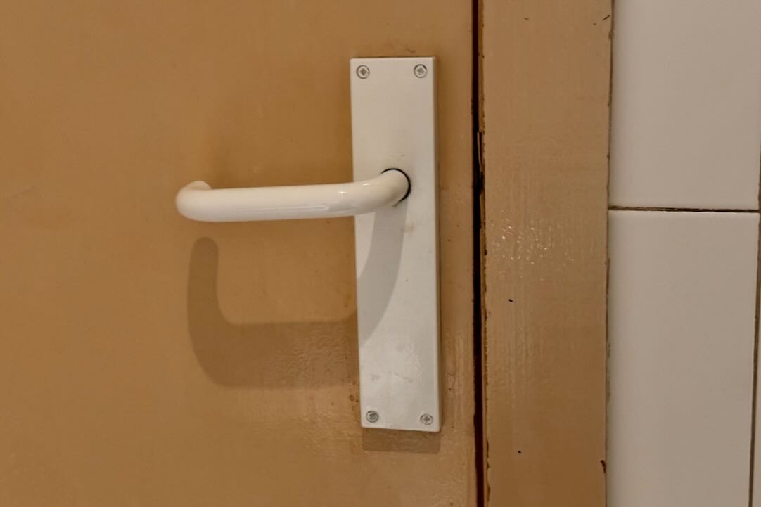 Mecanismo apertura de la puerta del aseo accesible (interior)